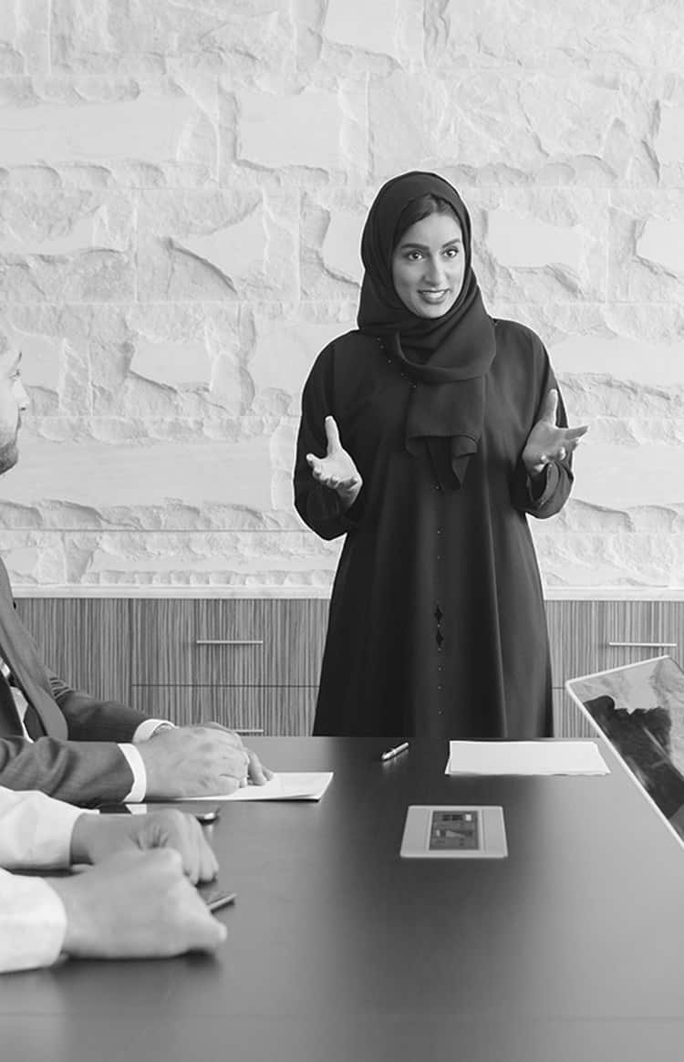 Emirati businesswoman presenting ideas to a diverse team in a meeting