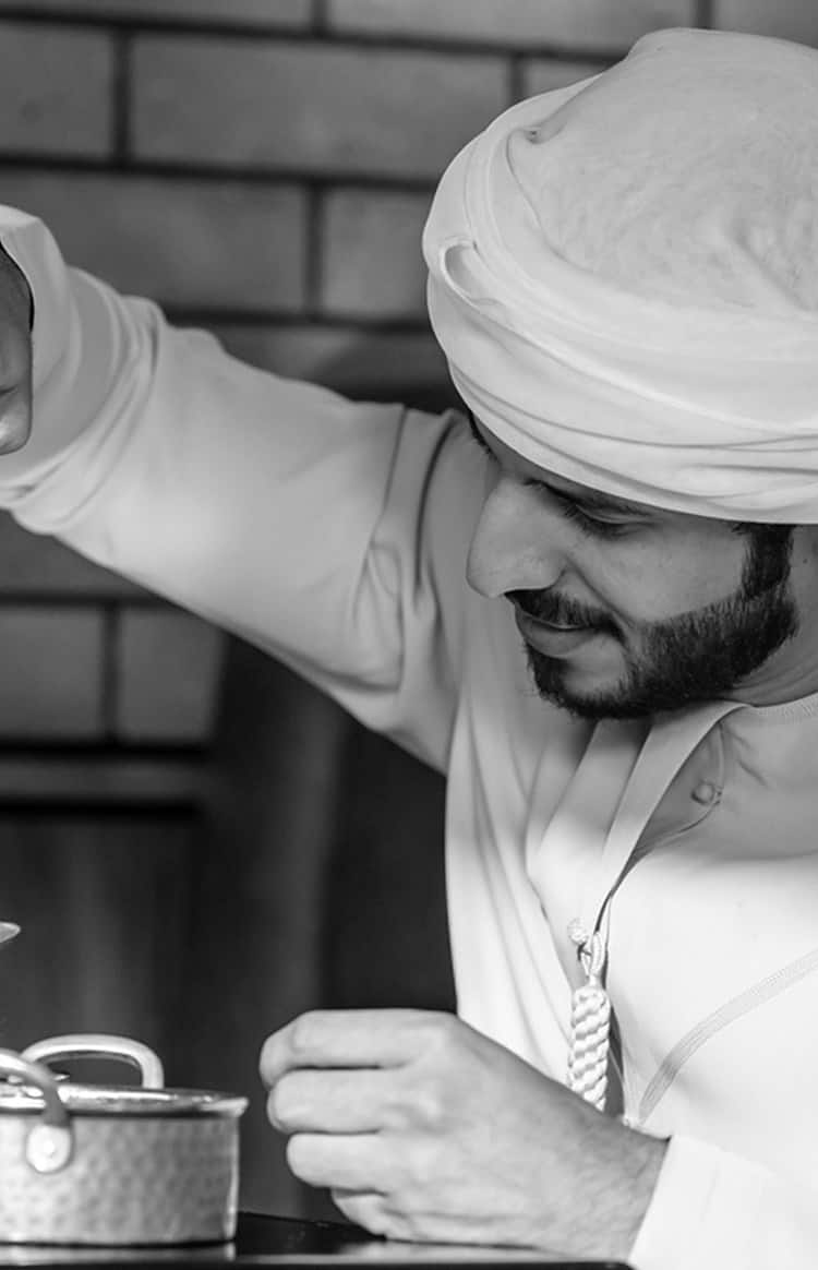 Chef working on food preparation in a professional kitchen